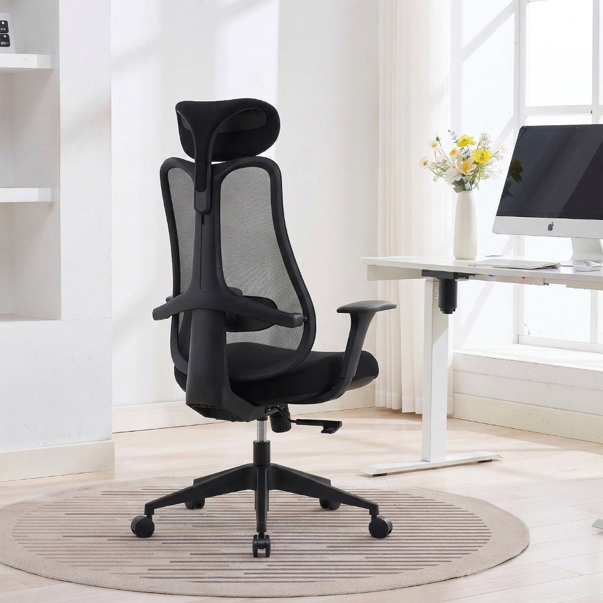 NHO-0024BL,Black office chair in a modern office setting with a desk and computer.