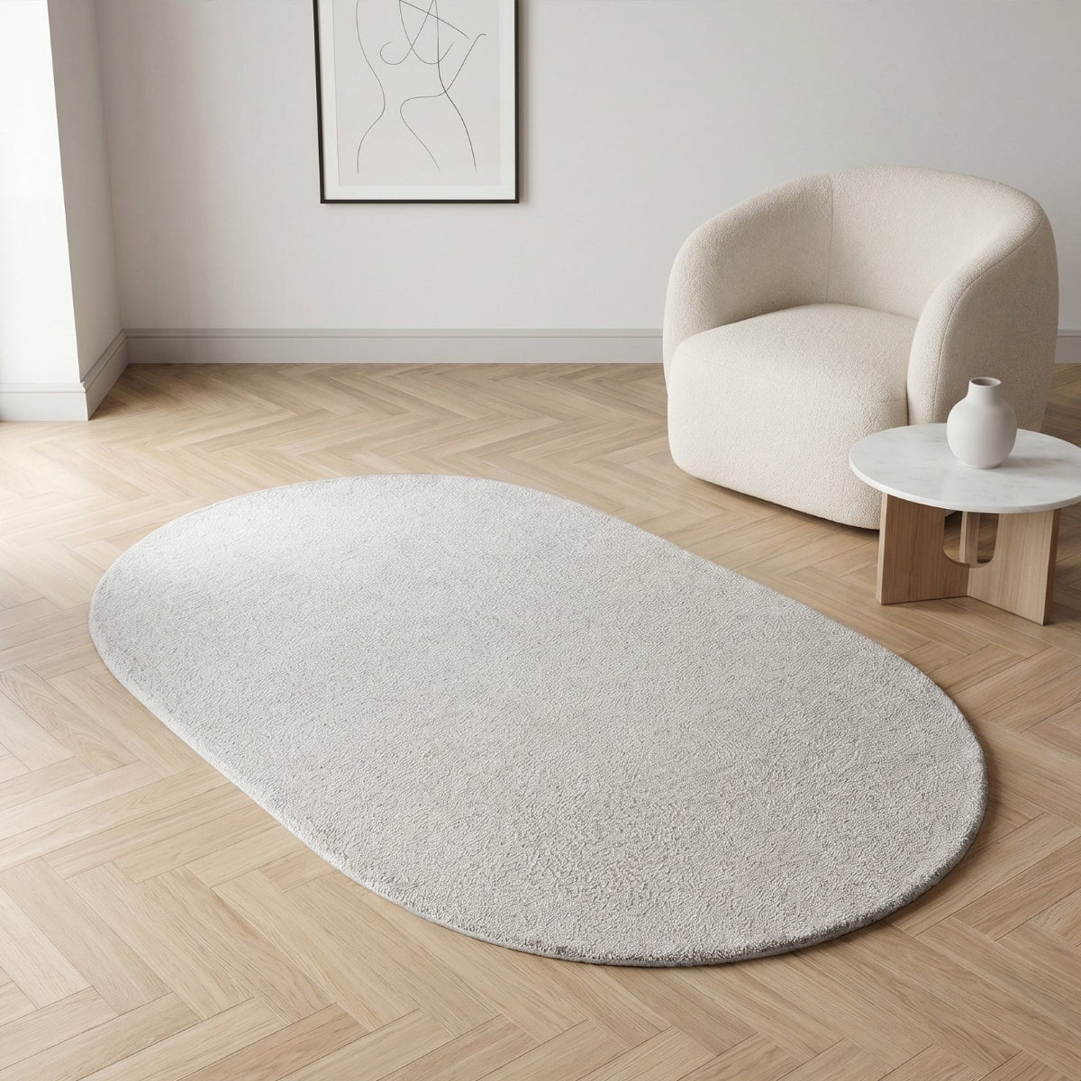NA-OR148F-GR,Oval-shaped white rug on a wooden floor with a modern chair and table in the background.