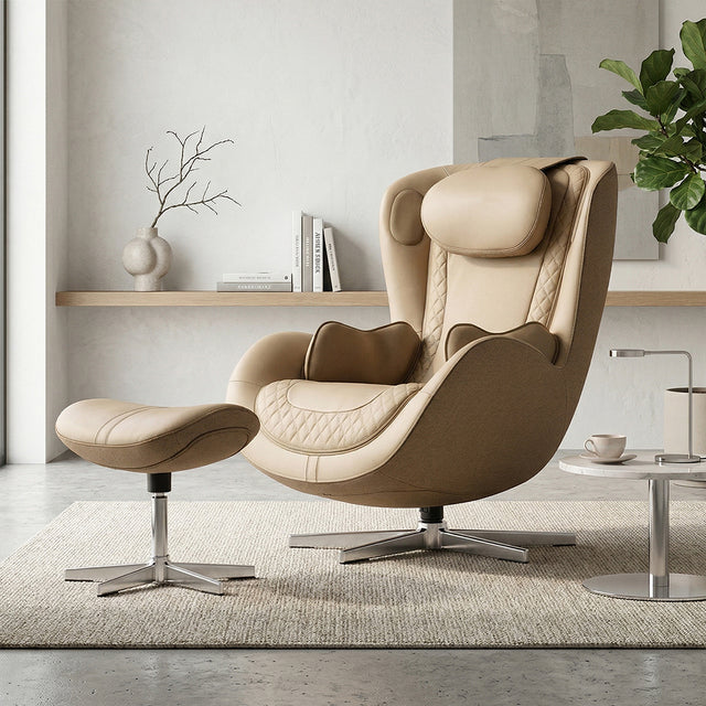 N-0004SD-V2, Mellow Sand ergonomic massage armchair with matching ottoman in a bright, modern American living room during a sunny daylight saving time afternoon. The chic beige and tan lounger is set on a neutral textured rug, next to a small marble side table with a coffee cup. The background features clean white walls, minimalist wooden shelving with decor, and a lush green fiddle-leaf fig plant, illuminated by warm, natural sunlight streaming through a large window.
