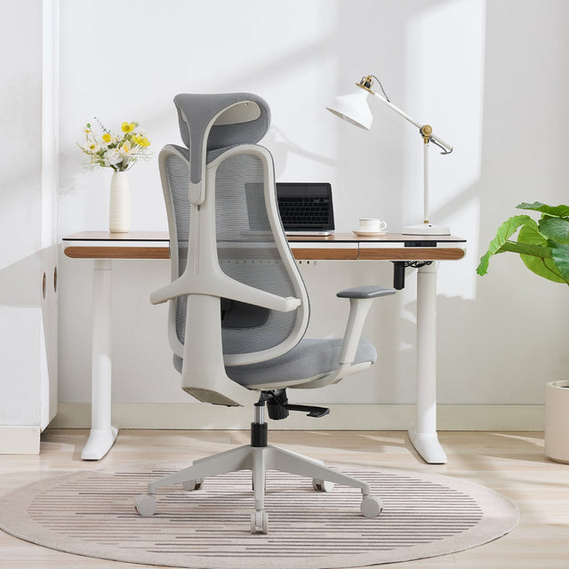 NHO-0024GR,Modern office chair in front of a desk with a laptop and lamp in a bright room.