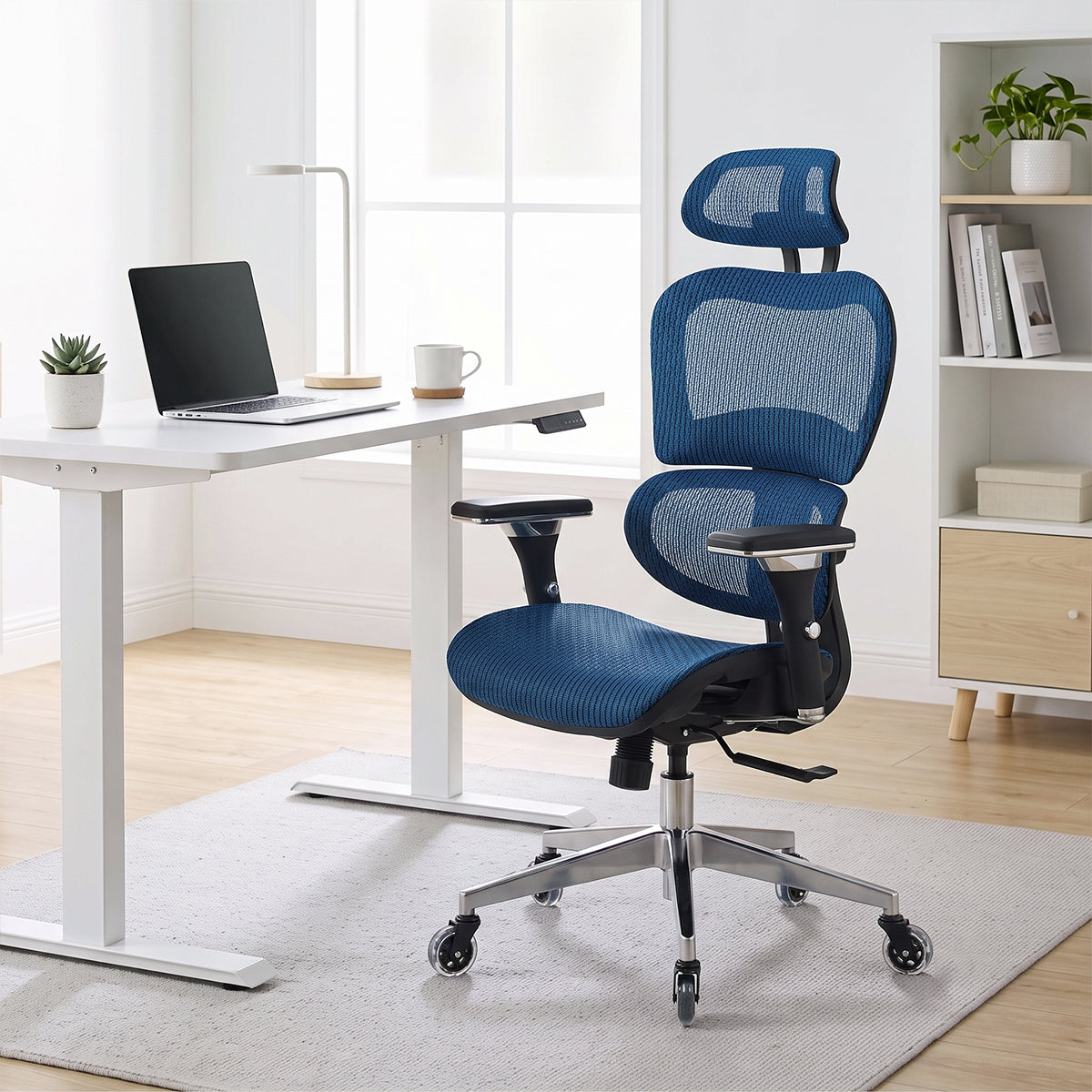 NHO-0001BU-V2, Brilliant Blue ergonomic mesh office chair in a bright, modern home office during a sunny afternoon. The high-back blue chair features an adjustable headrest, lumbar support, and a polished silver base with rollerblade casters, resting on a light grey rug. In the background, natural sunlight illuminates a minimalist white standing desk with a laptop and a nearby bookshelf.