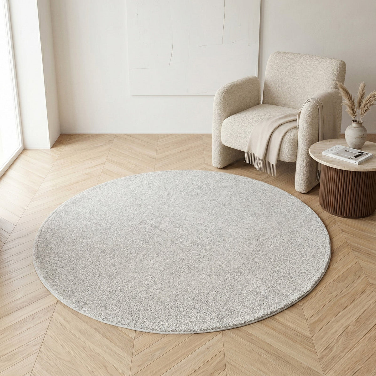 NA-RR120F-GR,Round beige rug in a room with a chair and small table.