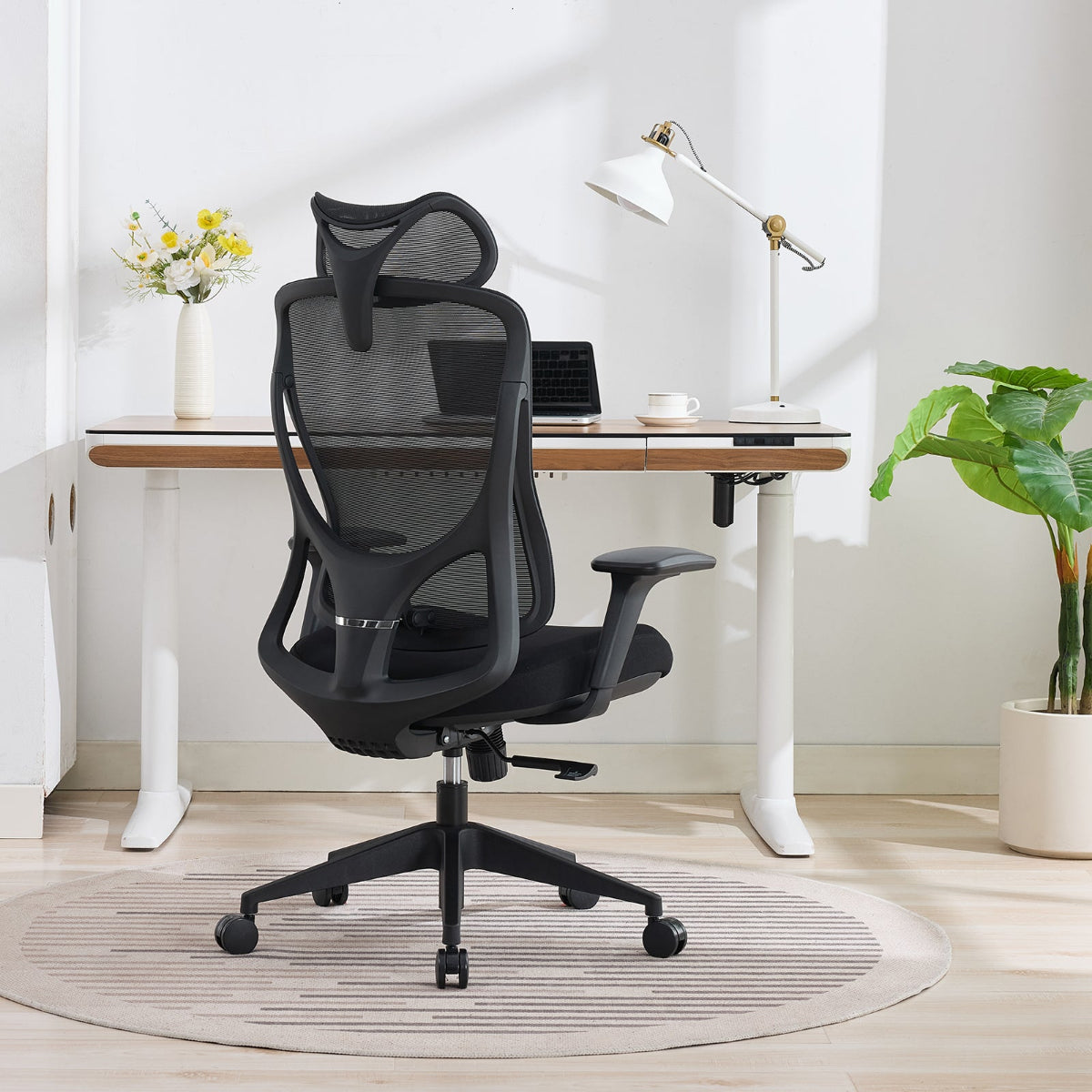 NHO-0026BL,Black office chair in a modern home office setting with a desk and lamp.