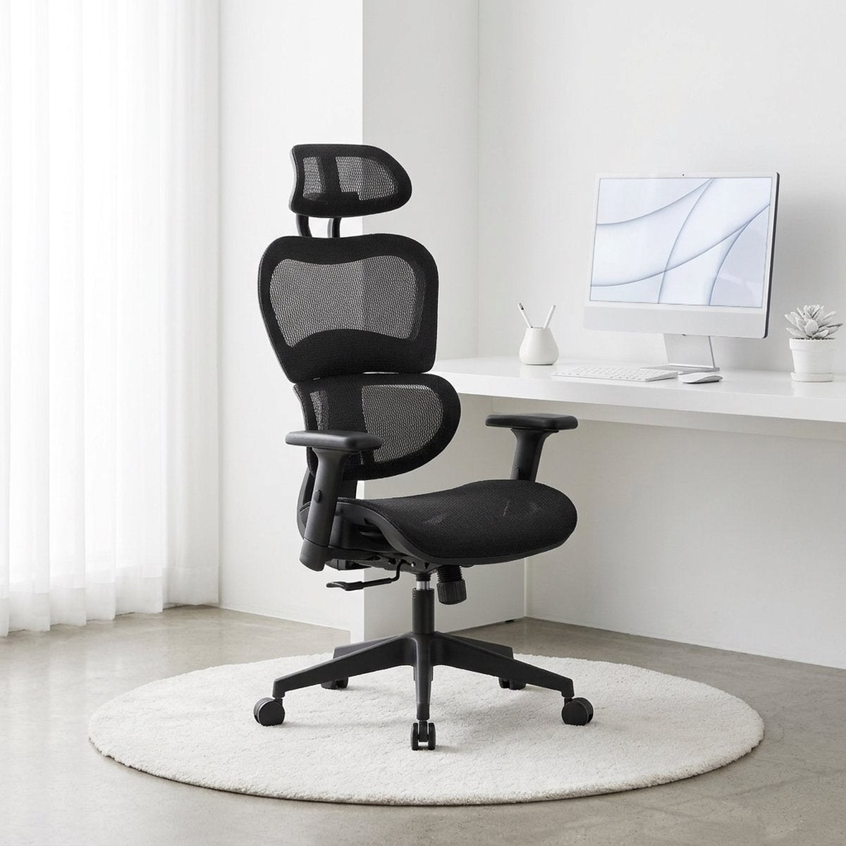 NHO-0001BL-L,Black ergonomic office chair in a modern office setting with a computer monitor.